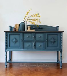 a blue dresser with flowers and books on top