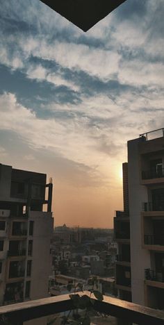 the sun is setting over some buildings in an area with high rise apartment blocks and balconies