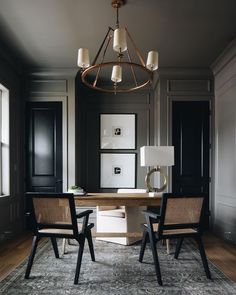 two chairs are sitting at a table in the middle of a room with black walls