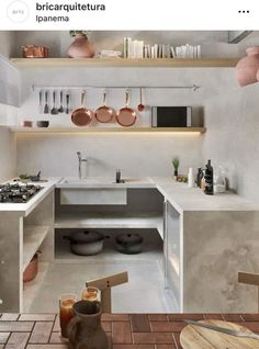 a kitchen with pots and pans on the shelves above the sink, along with other utensils