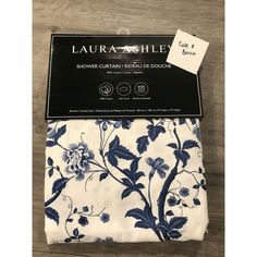 two pieces of blue and white floral fabric on a wooden surface with the packaging for each piece