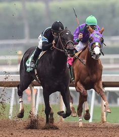 two jockeys on horses racing down the track