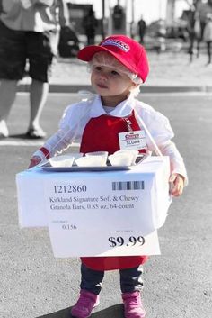 a small child in red and white holding a box