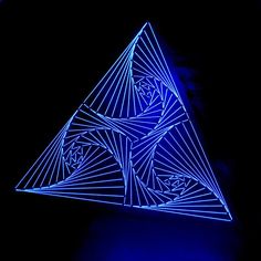 a triangle shaped object lit up in the dark with blue light on it's side