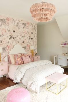 a bedroom with pink furniture and wallpaper