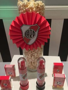 popcorn bar with red and white striped paper fans, candy bars and candies in glass jars