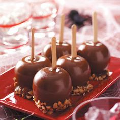 chocolate covered candies on a red plate with toothpicks sticking out of them