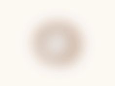 an image of a white circle on a beige background with the light reflecting off it's center