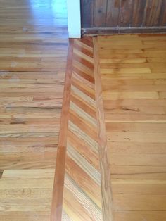 an empty room with wooden floors and hard wood flooring on the ground, looking down