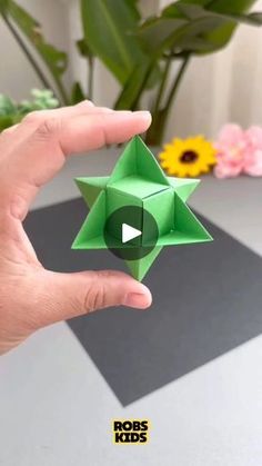 a person holding an origami star in their hand with the text rob's kids on it