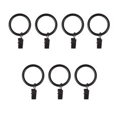 six pairs of black metal rings on white background