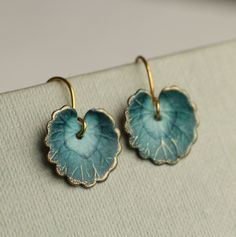 These leaf earrings are brass charms with some amazing detail, which have been carefully painted and varnished to bring out beautiful, cool toned shades of French navy blue!  The colour is applied to reveal touches of gold on the veins of the leaf.  They remind us of beautiful watercolour lily pads from a Monet painting.     Each pair is hand painted in our Edinburgh studio and no two pairs are quite the same! Each leaf is 15mm long. We offer these leaf earrings in three length options.  ★ SHORT (2.5cm) hangs just below the earlobe. ★ MEDIUM (3.5cm) leaf hangs an inch below the earlobe ★ LONG (5cm) leaf will hang at jawline level. The ear wires are made from solid brass.   🖤 FASTER SHIPPING 🖤 Need this fast? We offer a Faster Shipping option here: https://www.etsy.com/uk/listing/10010731 Hand Painted Brass Earrings As Gift, Hand Painted Brass Earrings For Gifts, Blue Teardrop Earrings With Patina, Blue Patina Earrings For Gift, Blue Leaf-shaped Jewelry Gift, Blue Leaf-shaped Jewelry For Gift, Handmade Blue Leaf-shaped Jewelry, Patina Drop Earrings As Gift, Watercolour Lily