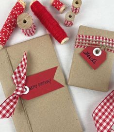 two brown boxes with red and white checkered ribbon on them, one has a happy birthday tag attached to it