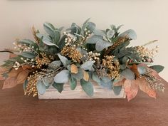 a wooden box filled with leaves and flowers