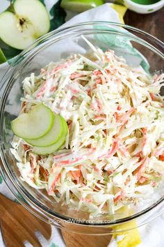 a glass bowl filled with coleslaw and apple slices