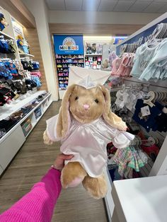 a person holding a stuffed animal in a store