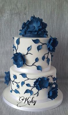 a three tiered cake with blue flowers on it