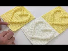 someone crocheting the letters on top of two knitted squares