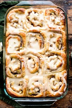 a casserole dish filled with rolls covered in white sauce and topped with mushrooms