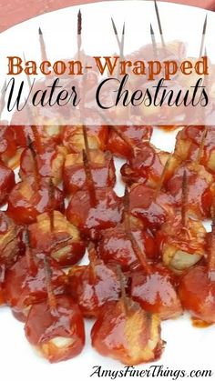 bacon wrapped water chestnuts on a white plate with toothpicks in the middle