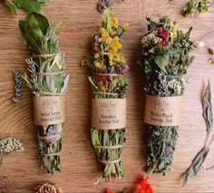 three bundles of wildflowers tied to twine on a wooden table with flowers around them