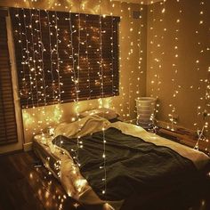 a bed that has some lights on the headboard and it is covered in string lights