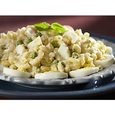 a blue plate topped with macaroni salad and cucumber garnish