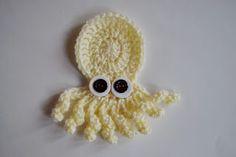 an octopus crocheted hat with googly eyes on it's head, sitting on a white surface