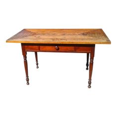 an old wooden table with two drawers on one side and three legs on the other