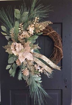 a wreath is hanging on the front door with pine cones and evergreens around it