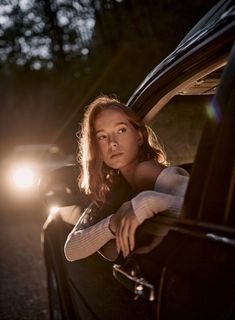 a woman leaning out the window of a car