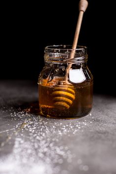 a wooden stick sticking out of a jar filled with honey