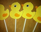 four yellow ducky lollipop sticks on a table