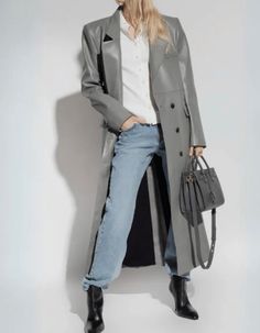 GREY DOUBLE BREASTED LONG TRENCH JACKET FOR LADIES Upgrade your style with the Karen Grey Women's Leather Trench Coat, a flawless blend of timeless elegance and contemporary allure; this long coat is a versatile and sophisticated wardrobe staple for the modern woman. Made from authentic leather in a bold, glossy grey tone, The lapel collar and double-breasted design radiate classic sophistication, while the soft inner lining ensures all-day comfort. With convenient details, including two exterio Chic Gray Outerwear For Work, Chic Gray Business Outerwear, Gray Spring Outerwear With Double Button Closure, Gray Spring Outerwear For Office, Chic Gray Outerwear For Spring, Chic Gray Single-breasted Outerwear, Leather Trench Coat Woman, Grey Trench Coat, Long Trench