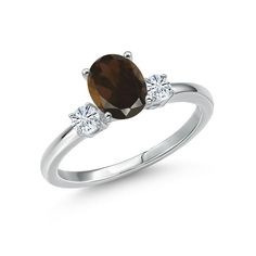 a white gold ring with an oval brown diamond and three diamonds on the side, set in