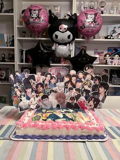 a birthday cake on a table in front of some decorations and balloons with pictures of people