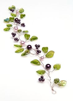 a necklace with green leaves and black pearls