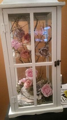 an old china cabinet with flowers in it