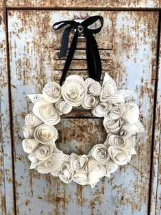 an old door with a wreath made out of paper flowers hanging from the front and side