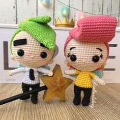 two crocheted dolls standing next to each other with a star on the floor