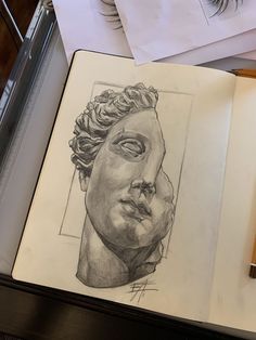 an open book with a drawing of a man's head on top of it