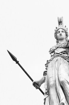 a black and white photo of the statue of lady justice holding a spear in her hand