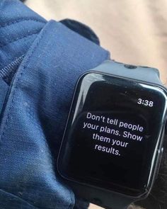 a person wearing a smart watch with a message on it's screen that reads, don't tell people your plans show them your results