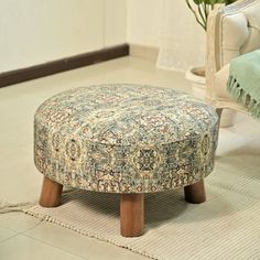 a foot stool sitting on top of a white floor next to a chair and rug