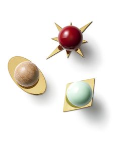 three different shapes and sizes of objects on a white surface with one red ball, the other green