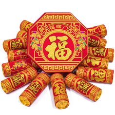 a red and gold decoration with chinese writing on the top is surrounded by smaller rolls