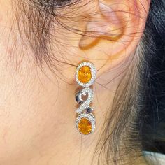 ENJOY OUR WORRY-FREE SERVICE AND THE DAZZLING, GENUINE JEWELRY WE DESIGN AND HANDCRAFT WITH LOVE❤️ ABOUT THE ITEM: SPARKLING! SHIMMERING, DANGLING VIVID ORANGE YELLOW SAPPHIRE EARRINGS! SO PRECIOUS! CERTIFIED 12.68 Total Carats, with 4 pieces of Thai yellow sapphires and 1.21 carats of F/VS, natural diamonds, set in handmade 10.0 grams, 18K solid white gold, CHIC dangling earrings. One of a kind! At 3.6 centimeter in drop length, perfect for both formal and causal events! ONE OF A KIND HANDCRAFT Yellow Halo Design Earrings For Gift, Exquisite Oval Diamond Earrings For Anniversary, Luxury Oval Earrings For Anniversary, Yellow Oval Fine Jewelry Earrings, Luxury Oval Diamond Earrings For Gift, Yellow Oval Earrings In Fine Jewelry Style, Yellow Oval Earrings Fine Jewelry, Dazzling Oval Earrings For Anniversary, Oval Earrings With Polished Finish For Anniversary