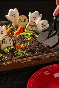 a cake decorated to look like halloween with tombstones and ghost heads on it,