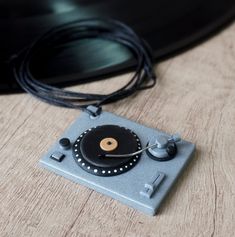 an old record player sitting on top of a wooden table next to a black object