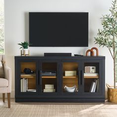 a flat screen tv sitting on top of a wooden entertainment center